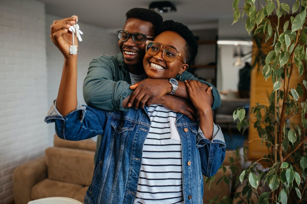 Couple cheerful home owners holding a key